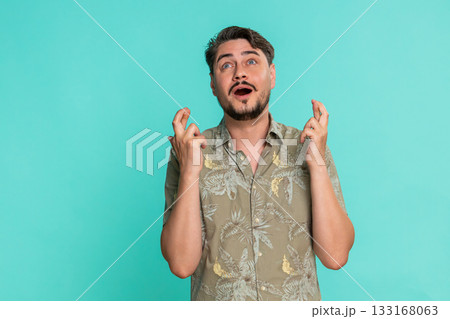 Adult man crossing fingers hoping for positive result good luck nervous emotion with hopeful gesture Adult man crossing fingers hoping for positive result good luck nervous emotion with hopeful gesture 133168063