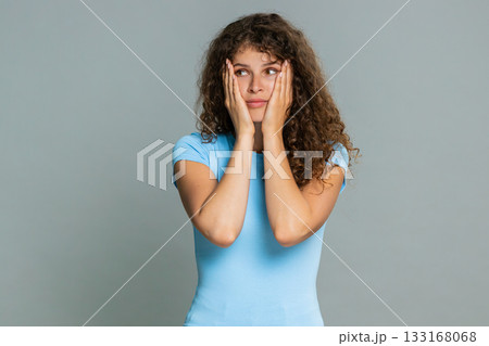 Young woman covering face with hands feeling embarrassed shy ashamed awkward emotional reaction 133168068