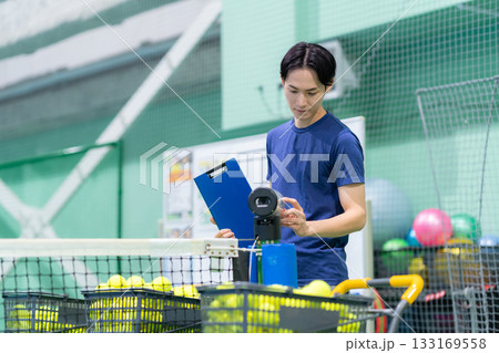 スポーツジムでテニスをする若い男性 撮影協力:スポーツクラブ&サウナスパ ルネサンス 幕張24 スポーツジムでテニスをする若い男性 撮影協力:スポーツクラブ&サウナスパ ルネサンス 幕張24 133169558