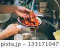 Person is washing strawberries in a sink 133171047