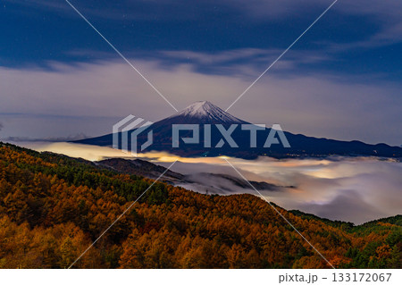 【山梨県】河口湖の湖上を覆う雲海と落葉松林の向こうに富士山 133172067