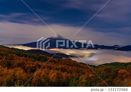 【山梨県】河口湖の湖上を覆う雲海と落葉松林の向こうに富士山 133172068