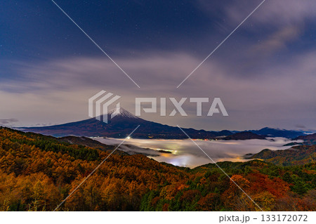 【山梨県】河口湖の湖上を覆う雲海と落葉松林の向こうに富士山 133172072