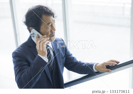 エスカレーターに乗るビジネスマン エスカレーターに乗るビジネスマン 133173611