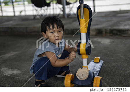 Focused Toddler Fixing Scooter, A sharp ad photo of a toddler intently fixing a scooter, tiny hands gripping tools under bright light, perfect for child development campaign or explorer documentary. Focused Toddler Fixing Scooter, A sharp ad photo of a toddler intently fixing a scooter, tiny hands gripping tools under bright light, perfect for child development campaign or explorer documentary. 133173751