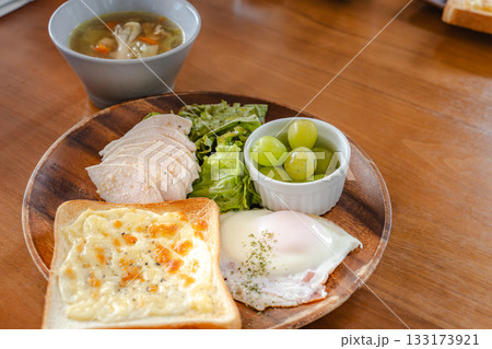 チーズトーストや目玉焼き、チキンを盛り付けた健康的な朝食プレート 133173921