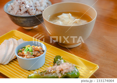 鶏むね肉や納豆、焼きししとうを盛り付けた健康的な和朝食 133174064