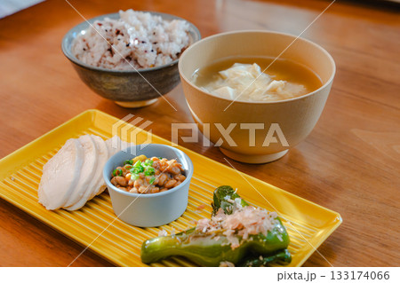 鶏むね肉や納豆、焼きししとうを盛り付けた健康的な和朝食 133174066
