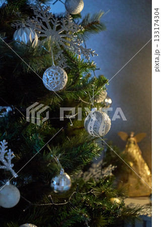 Festive Christmas tree decorated with red and golden ornaments, glowing string lights, creating a warm holiday atmosphere. 133174304