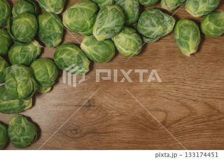 Fresh, raw brussel sprouts scattered on a rustic wooden table with copy space. Fresh, raw brussel sprouts scattered on a rustic wooden table with copy space. 133174451