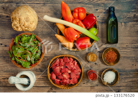 Fresh ingredients laid out for a healthy meal preparation in a rustic kitchen setting 133176520