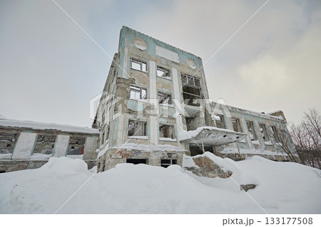 Abandoned building of the house of culture against the backdrop of a winter landscape and snow. Soviet architecture 133177508
