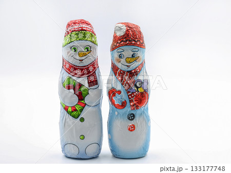 Chocolate snowmans wrapped in festive foil packaging closeup on white. 133177748