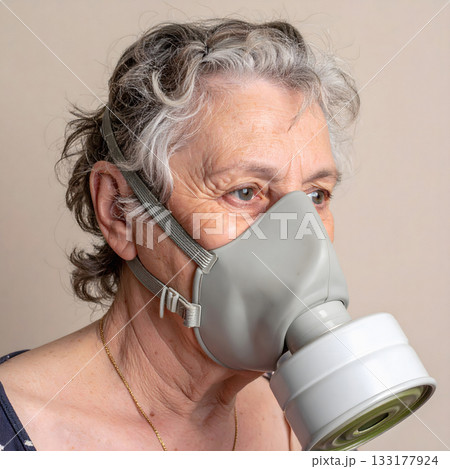 Elderly woman wearing gray gas mask indoors Elderly woman wearing gray gas mask indoors 133177924