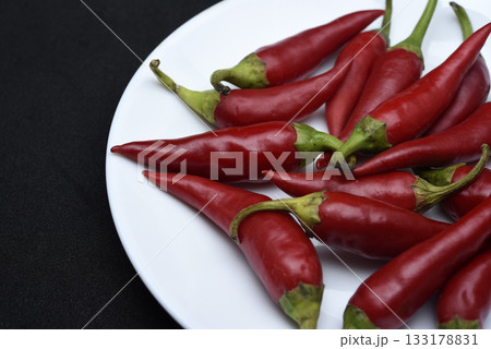 Red capsicum on a white plate. Red pepper pods. 133178831