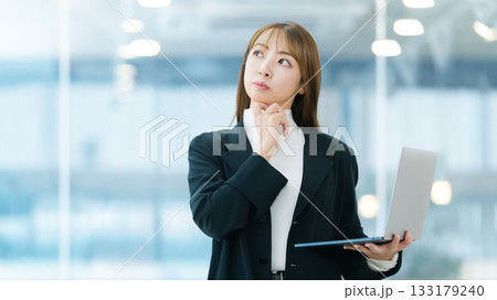 パソコンを持って考える女性ビジネスマン 133179240