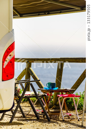 Camper and chairs on sea shore 133179505