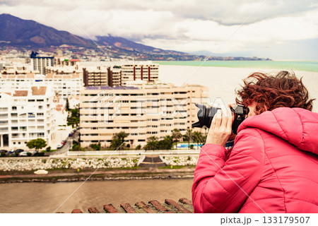 Woman with camera take photo in Fuengirola city, Spain 133179507