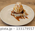キャラメルソースとバニラアイスをトッピングしたベイクドチーズケーキのカフェデザート 133179557