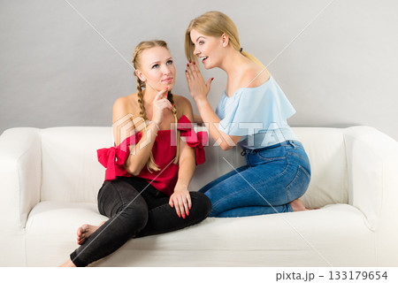 Two teen women gossiping Two teen women gossiping 133179654