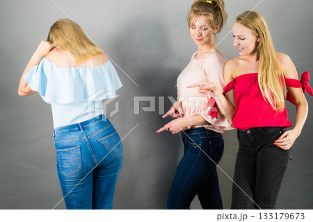 Woman being gossiped by two females Woman being gossiped by two females 133179673