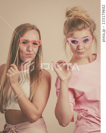 Two women holding carnival accessories Two women holding carnival accessories 133179682