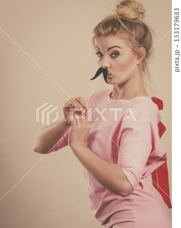 Happy woman holding fake moustache on stick 133179683