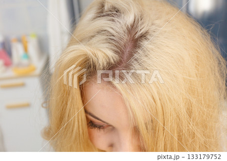 Woman showing blonde hair roots 133179752