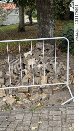 Stack of concrete bricks behind a metal fence, outdoor construction site background Stack of concrete bricks behind a metal fence, outdoor construction site background 133179861