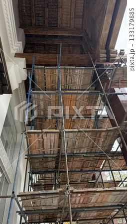 Scaffolding structure under wooden ceiling of building, offering construction background 133179885