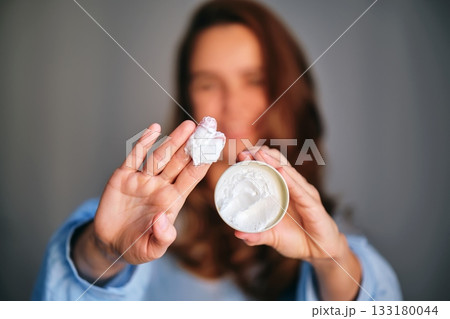 Woman applying beauty cream on fingers for skincare Woman applying beauty cream on fingers for skincare 133180044