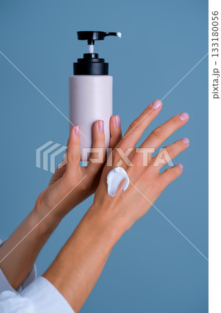 Woman applying moisturizing cream from pump bottle Woman applying moisturizing cream from pump bottle 133180056