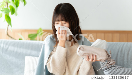 風邪を引いて鼻をかむ女性 133180617