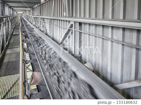 Belt conveyor transporting coal in a heating plant, selective focus. Belt conveyor transporting coal in a heating plant, selective focus. 133180632