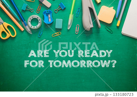 Colorful stationery supplies arranged on a green chalkboard background with motivational text 133180723