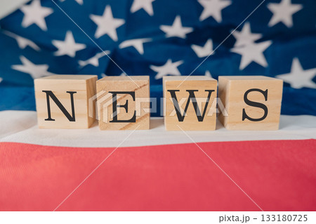 Wooden blocks spelling news on a background of an American flag with vibrant colors and textures Wooden blocks spelling news on a background of an American flag with vibrant colors and textures 133180725