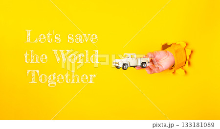 Hand holding a toy truck with the words Lets save the world together Hand holding a toy truck with the words Lets save the world together 133181089