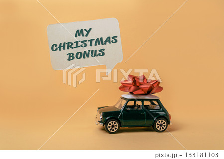 Toy car with red bow on top and speech bubble displaying festive message for holiday season 133181103