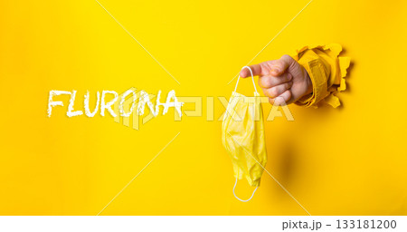 Person holding a yellow mask with the word Fluorna written in white Person holding a yellow mask with the word Fluorna written in white 133181200