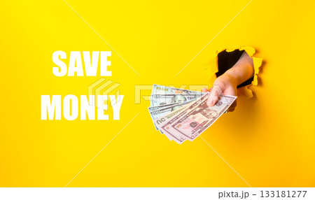 Hand holding a stack of money with the words save money written below 133181277
