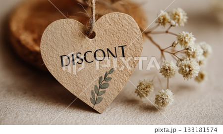 Heart-shaped discount tag with natural elements and dried flowers on a textured background 133181574