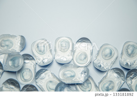 Many daily contact lenses in a disposable protective case lie at the bottom on a white background with space for text. The concept of ophthalmology, vision correction, eye care. High quality photo Many daily contact lenses in a disposable protective case lie at the bottom on a white background with space for text. The concept of ophthalmology, vision correction, eye care. High quality photo 133181892