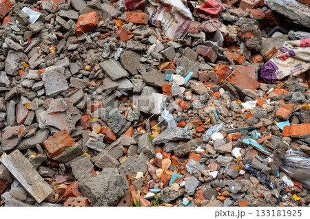 Debris and debris from building renovations in a construction waste container. Shattered, broken construction waste as pieces of cinder block concrete rubbles Debris and debris from building renovations in a construction waste container. Shattered, broken construction waste as pieces of cinder block concrete rubbles 133181925