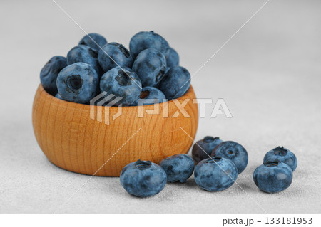 Fresh ripe blueberries in wooden bowl on light gray stone background closeup macro healthy food Fresh ripe blueberries in wooden bowl on light gray stone background closeup macro healthy food 133181953