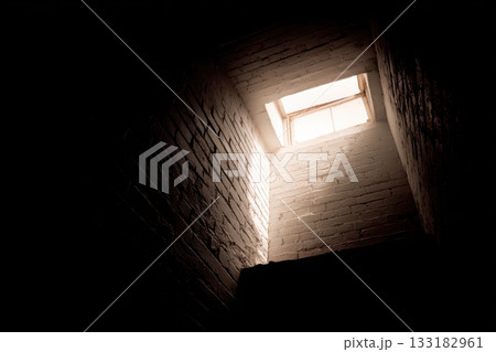Light streaming through an open window in a staircase 133182961