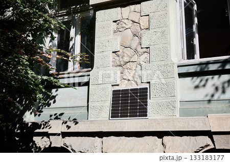 Photovoltaic solar panel in front of historical building. Concept of integration of sustainable renewable energy sources into old architecture. 133183177