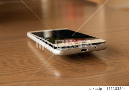 テーブルに置かれたモバイルバッテリーの膨張したスマートフォン テーブルに置かれたモバイルバッテリーの膨張したスマートフォン 133183244