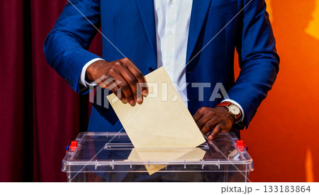 Voting poster black man in a blue business suit dropping a ballot into a transparent ballot box during voting, a concept of electoral freedom and democratic voting procedures Voting poster black man in a blue business suit dropping a ballot into a transparent ballot box during voting, a concept of electoral freedom and democratic voting procedures 133183864