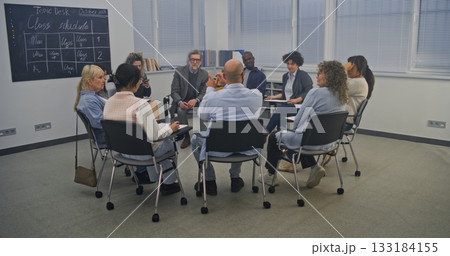 Diverse Group of Adult Students Sits in Circle Inside Modern Classroom 133184155