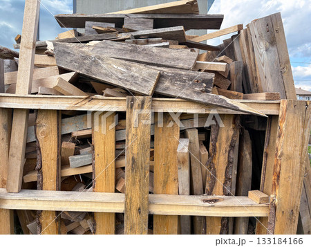 A pile of used broken lumber is stacked at a construction site 133184166